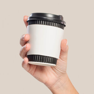 Person holding a Coffee Cup with Coffee Sleeve