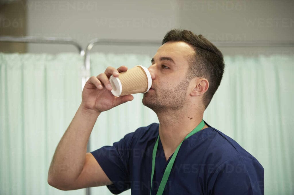 Man drinking from disposable paper cup